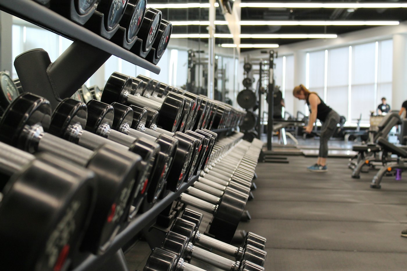 Sala de pesas de un gimnasio con mancuernas y máquinas