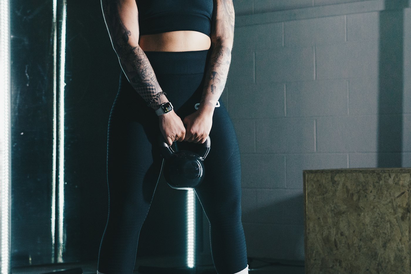 Mujer sosteniendo una kettlebell en un gimnasio